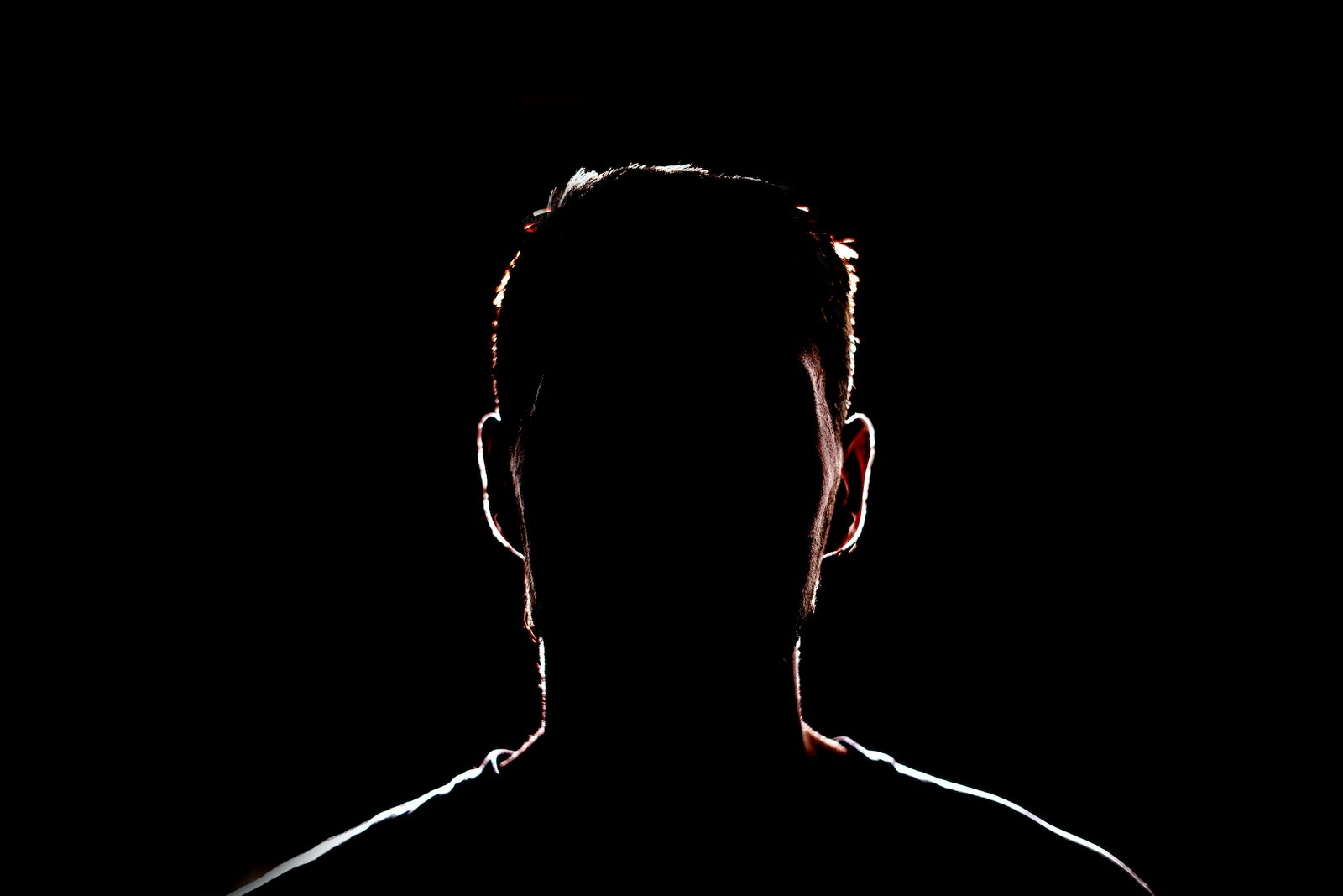 a dark backlight shadow silhouette of male person, incognito unknown profile